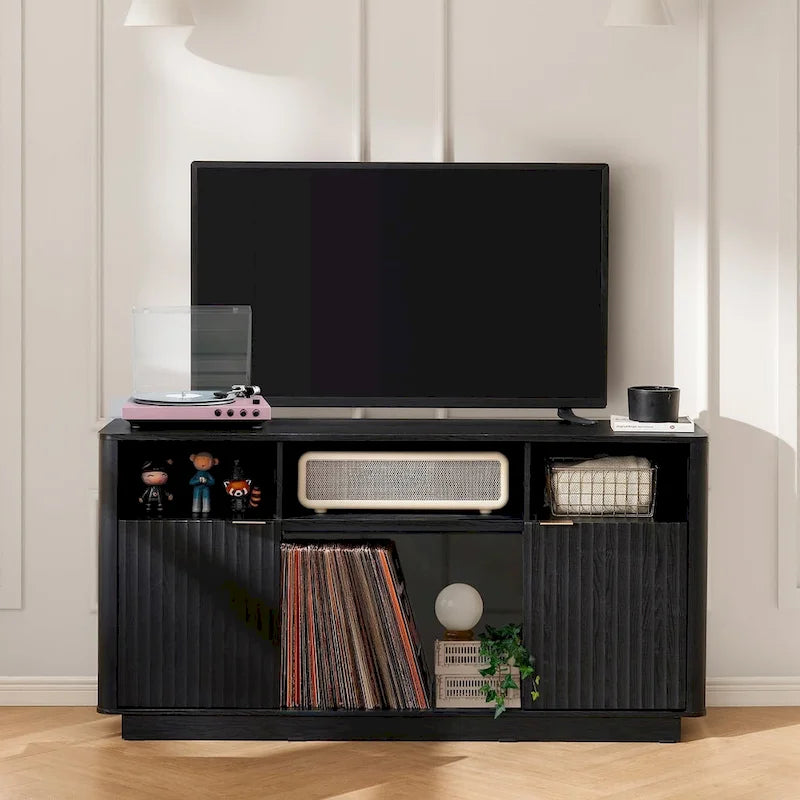 Meuble TV avec cheminée électrique, panneaux cannelés et poignées dorées, noir